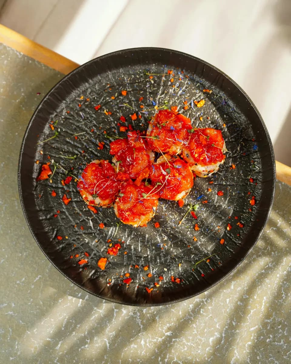 A seafood dish plated on a black background